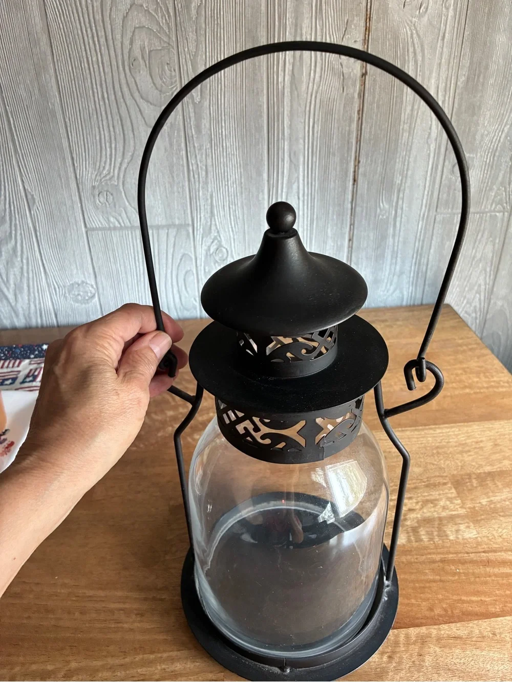 Decorative black metal hurricane lantern/candle lantern. It has a clear glass
